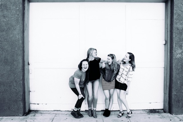 Four teenage girls standing together with arms around each other